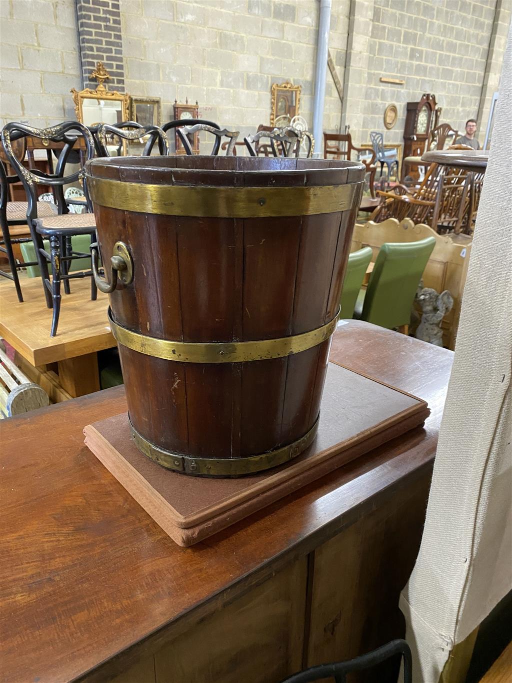 A George III circular brass bound mahogany peat bucket, fitted with two carrying handles, diameter 35.6cm, height 41cm